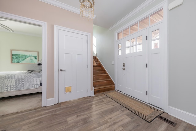 foyer featuring ornamental molding and light hardwood / wood-style flooring