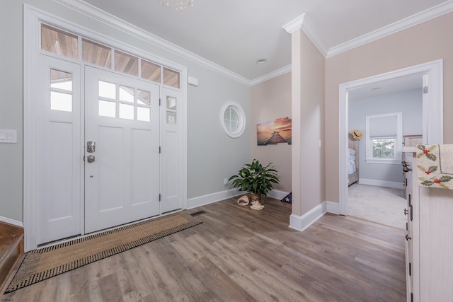 foyer entrance featuring ornamental molding and light hardwood / wood-style flooring