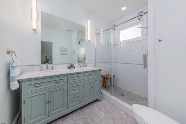 bathroom with a shower with door, vanity, and toilet