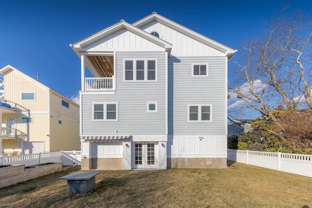 back of property with french doors and a lawn