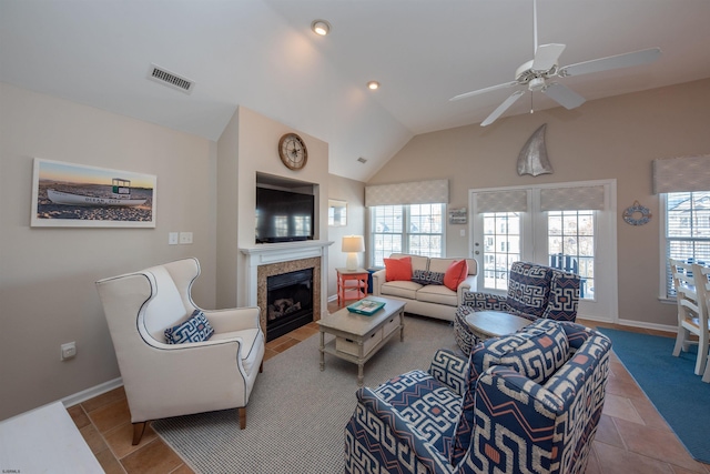 tiled living room with lofted ceiling, a tile fireplace, and ceiling fan