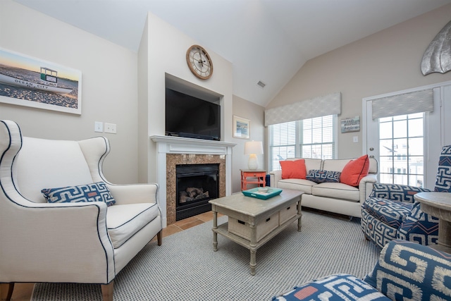 living room featuring lofted ceiling and a tiled fireplace