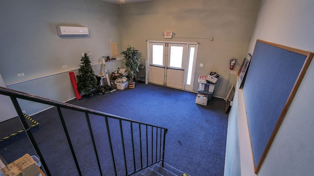 foyer entrance with an AC wall unit, dark carpet, and french doors