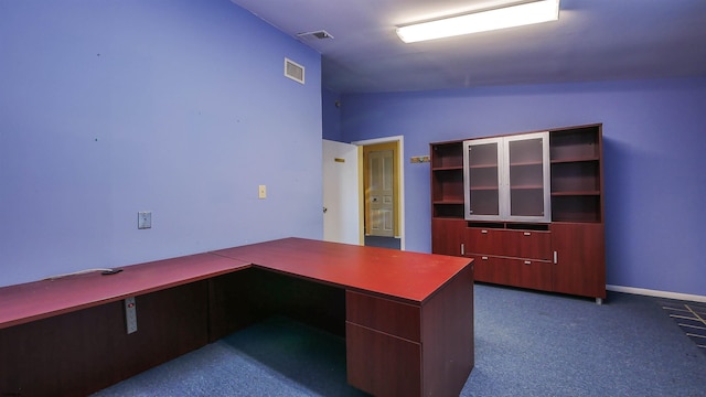 unfurnished office with dark colored carpet and vaulted ceiling