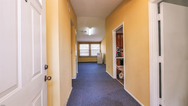 hall with dark colored carpet