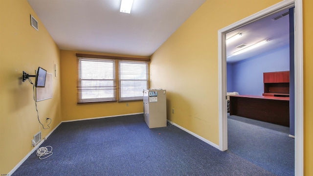 carpeted empty room featuring lofted ceiling