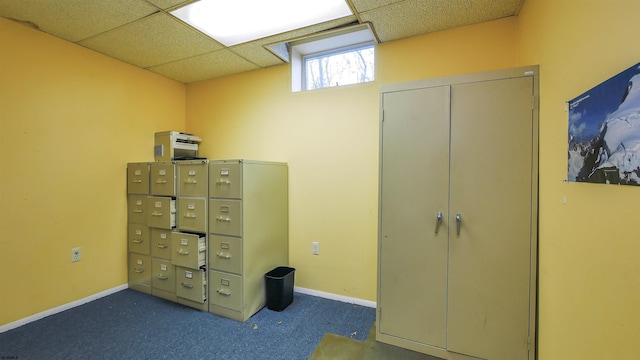 unfurnished bedroom featuring mail boxes, dark colored carpet, and a paneled ceiling