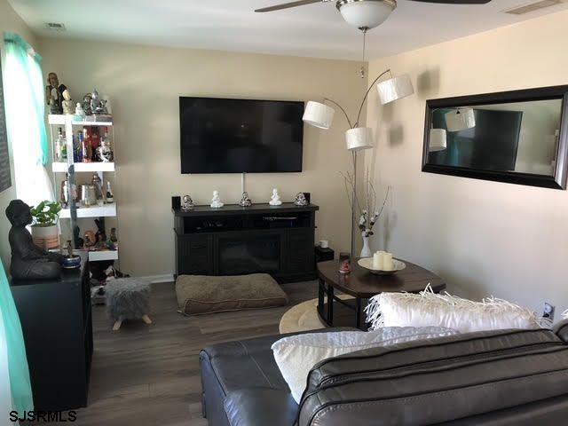 living room with wood-type flooring and ceiling fan