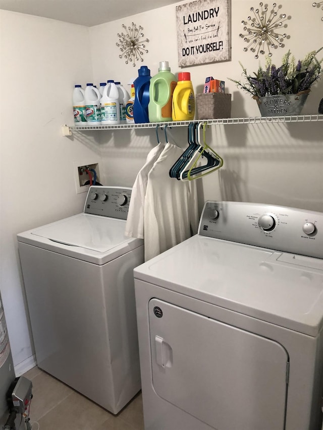 laundry area featuring light tile patterned floors and washer and clothes dryer