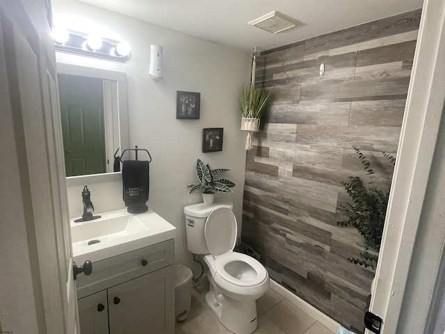 bathroom featuring tile patterned floors, vanity, toilet, and wood walls