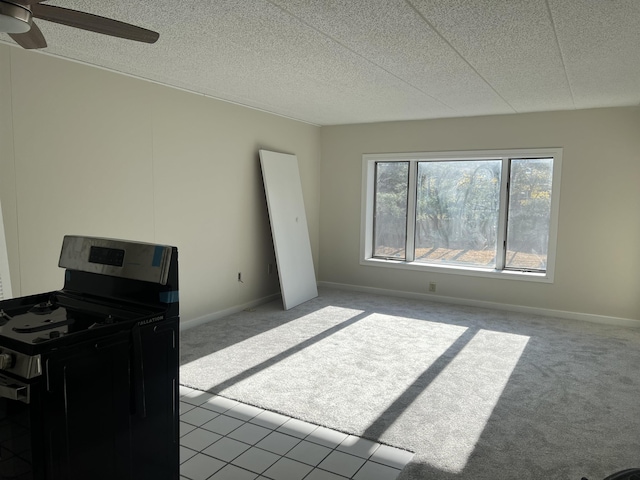 interior space featuring light carpet, ceiling fan, electric range, and a textured ceiling