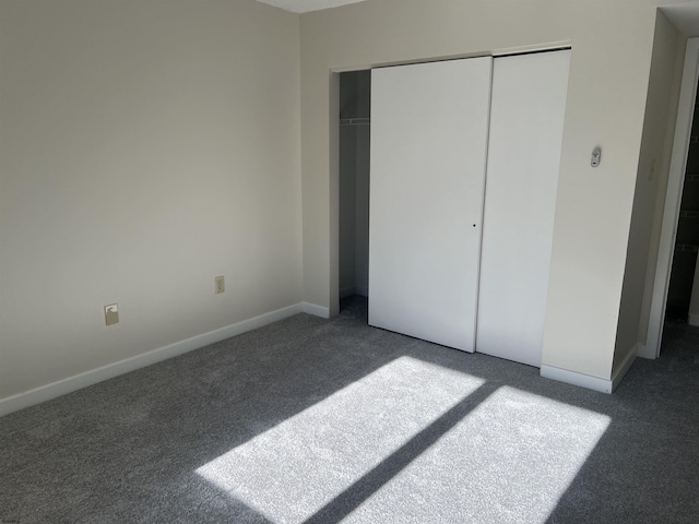 unfurnished bedroom featuring a closet and dark colored carpet