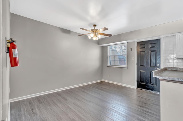 unfurnished living room with wood-type flooring and ceiling fan