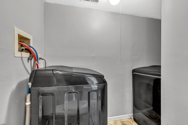 washroom featuring hardwood / wood-style floors and washing machine and dryer