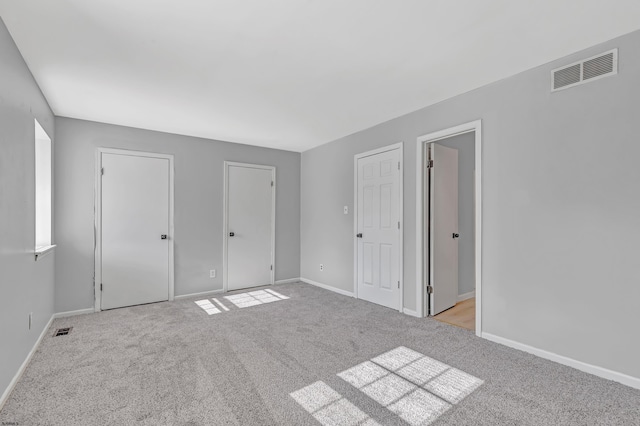 unfurnished bedroom featuring light carpet