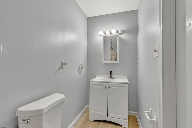 bathroom featuring vanity, toilet, and hardwood / wood-style floors