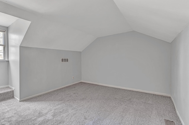 bonus room featuring lofted ceiling and light carpet