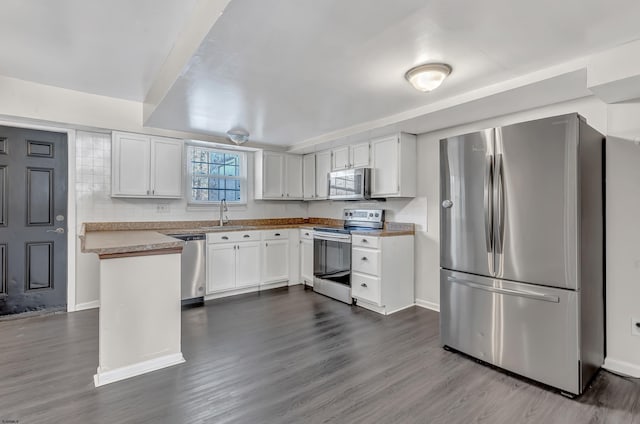 kitchen with hardwood / wood-style flooring, appliances with stainless steel finishes, sink, and white cabinets