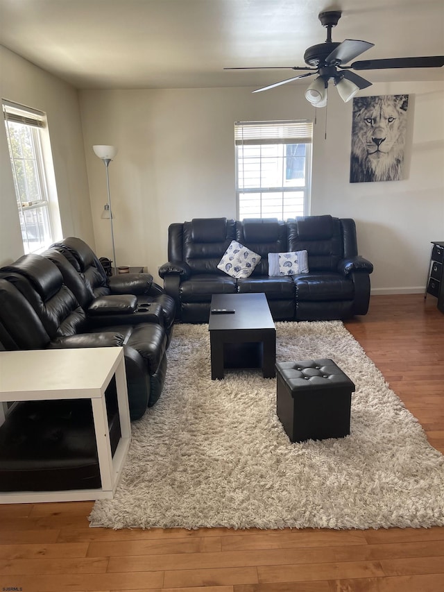 living room with wood-type flooring, plenty of natural light, and ceiling fan