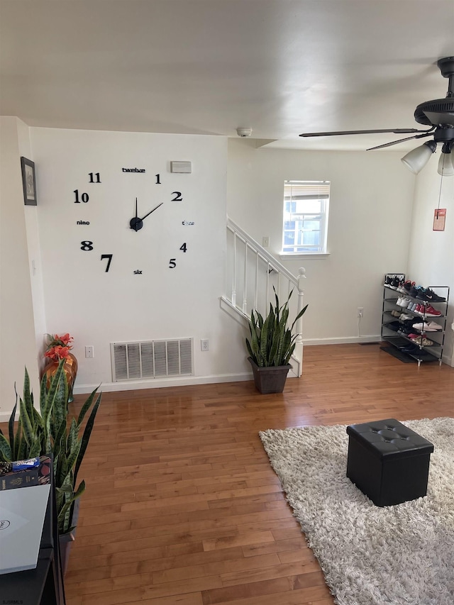 living room featuring ceiling fan and hardwood / wood-style floors