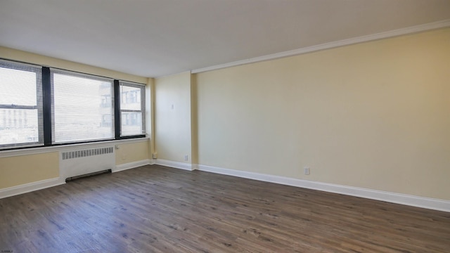 unfurnished room with radiator, dark wood-type flooring, and ornamental molding