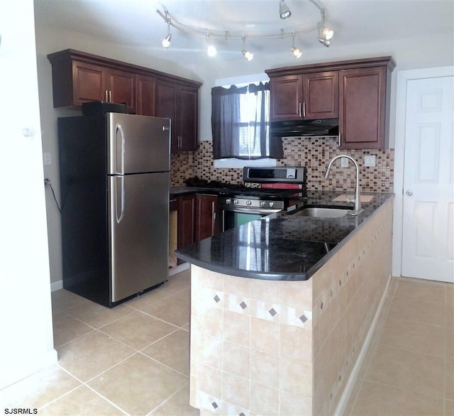 kitchen featuring sink, appliances with stainless steel finishes, tasteful backsplash, light tile patterned flooring, and kitchen peninsula