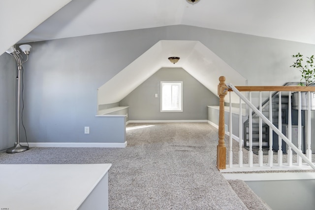 additional living space with carpet flooring and vaulted ceiling