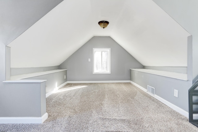 bonus room with light carpet and lofted ceiling