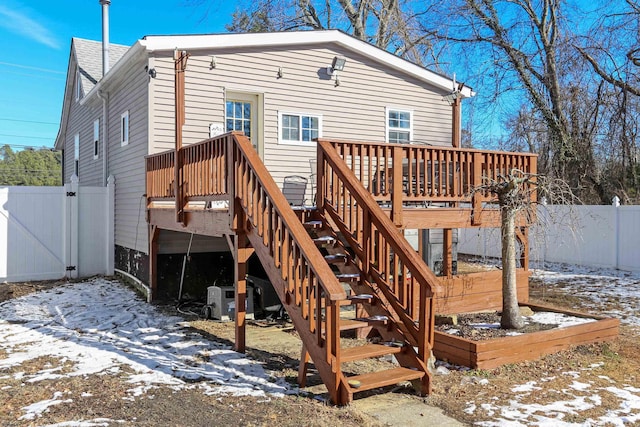 snow covered house with a wooden deck