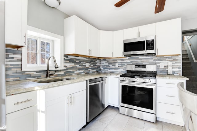 kitchen with stainless steel appliances, white cabinetry, sink, and tasteful backsplash