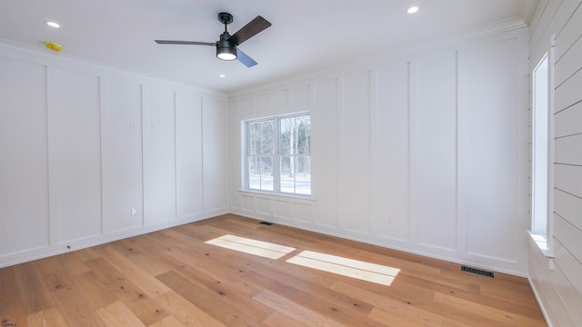 spare room featuring crown molding, ceiling fan, and light hardwood / wood-style floors