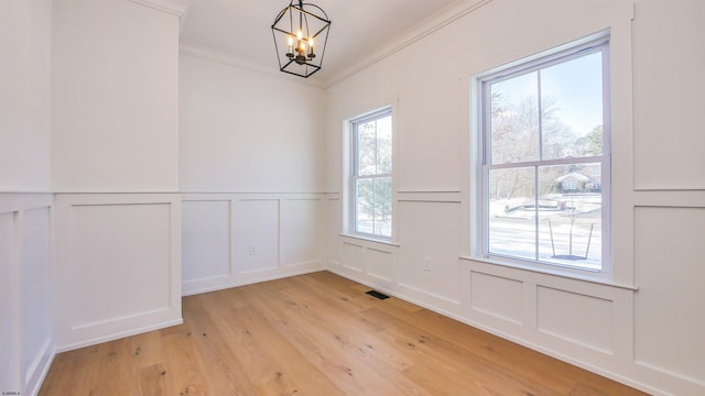 interior space with crown molding, light hardwood / wood-style flooring, and a notable chandelier