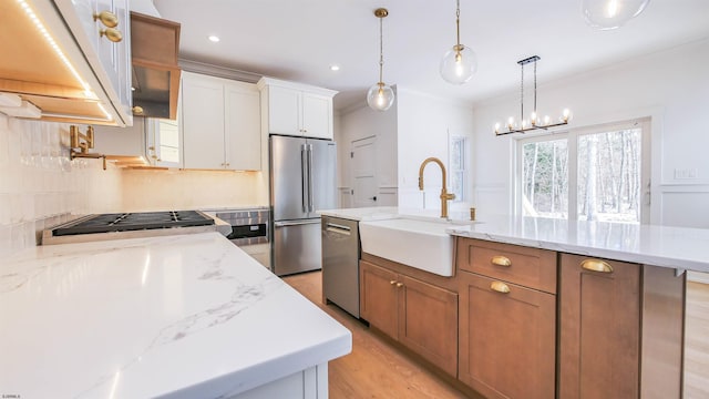 kitchen with sink, white cabinetry, a center island with sink, stainless steel appliances, and light stone countertops