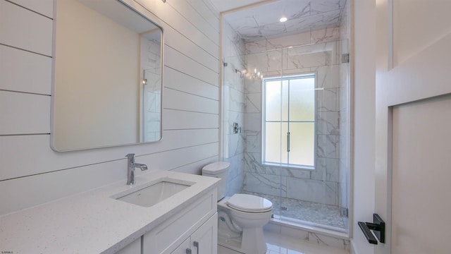 bathroom featuring vanity, a shower with shower door, and toilet