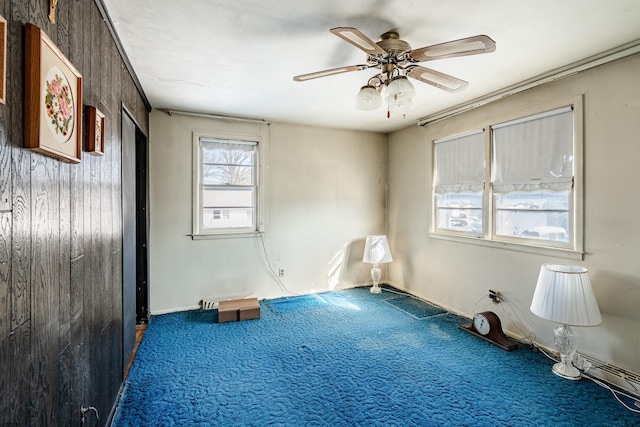 unfurnished room with ceiling fan and carpet