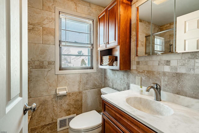 bathroom featuring vanity, tile walls, decorative backsplash, and toilet