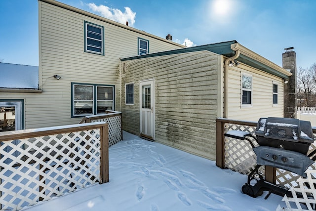 view of snow covered back of property