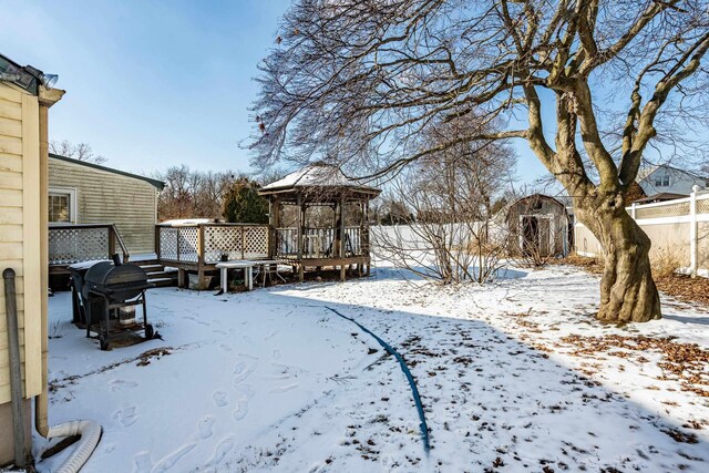 yard covered in snow with a gazebo and a deck