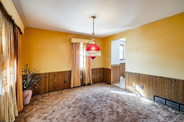 unfurnished dining area with carpet and wood walls