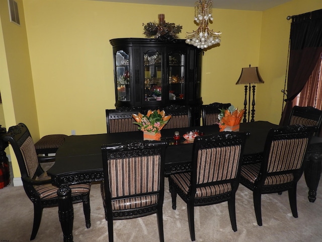 carpeted dining room with a chandelier