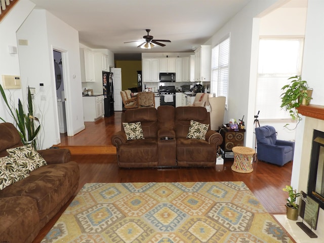 living room featuring dark wood-type flooring and ceiling fan