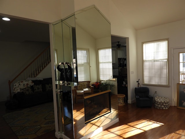 interior space with ceiling fan, wood-type flooring, vaulted ceiling, and plenty of natural light