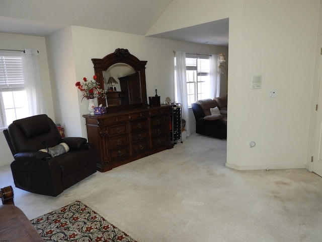 living area with vaulted ceiling and light colored carpet