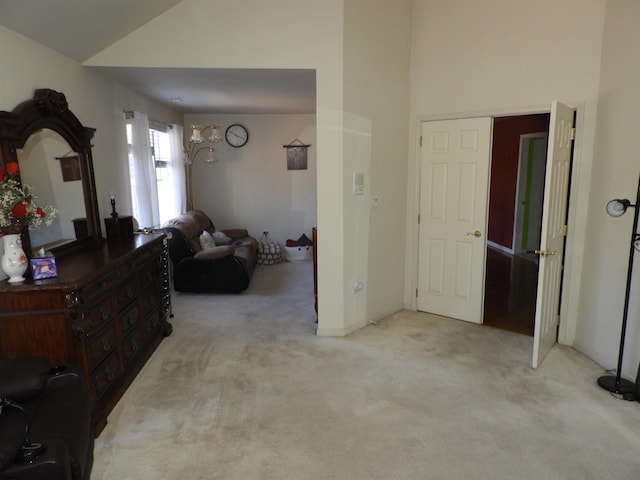 interior space featuring high vaulted ceiling and light colored carpet