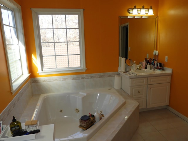 bathroom featuring tiled tub, vanity, and tile patterned flooring