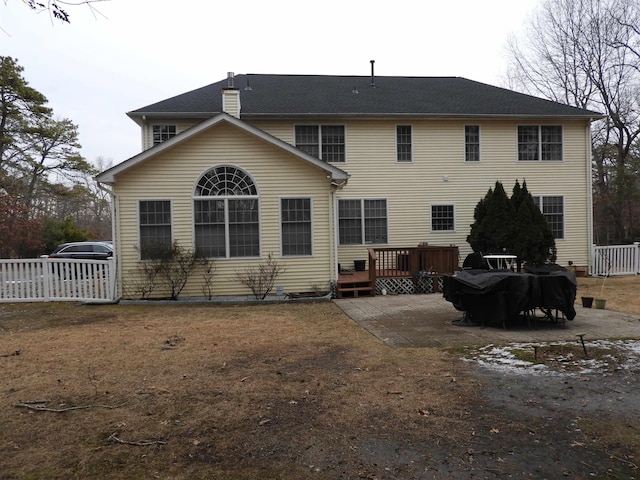 rear view of property featuring a wooden deck and a patio area