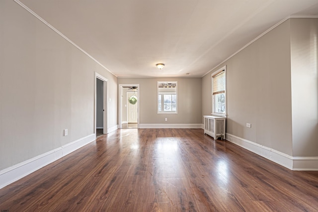 spare room with radiator heating unit, crown molding, and dark wood-type flooring