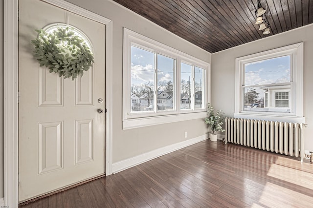 foyer entrance with wood-type flooring, radiator, a wealth of natural light, and wood ceiling