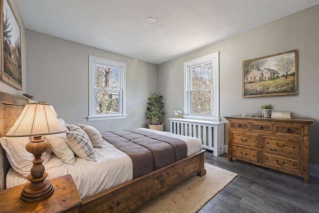 bedroom with dark wood-type flooring and radiator heating unit