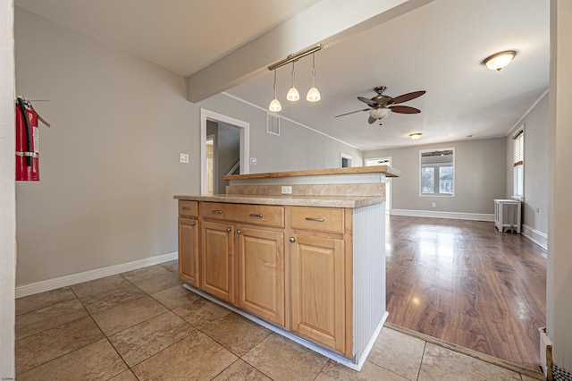 kitchen featuring light tile patterned flooring, radiator heating unit, pendant lighting, ornamental molding, and ceiling fan